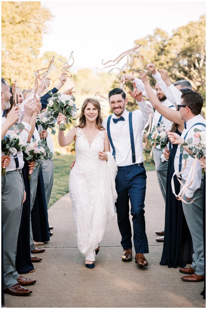 wedding couple surrounded by wedding party with streamers on wands